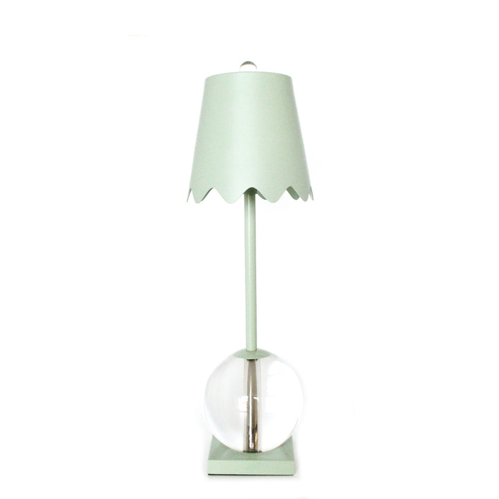 Mint green table lamp with a clear glass base on a white background