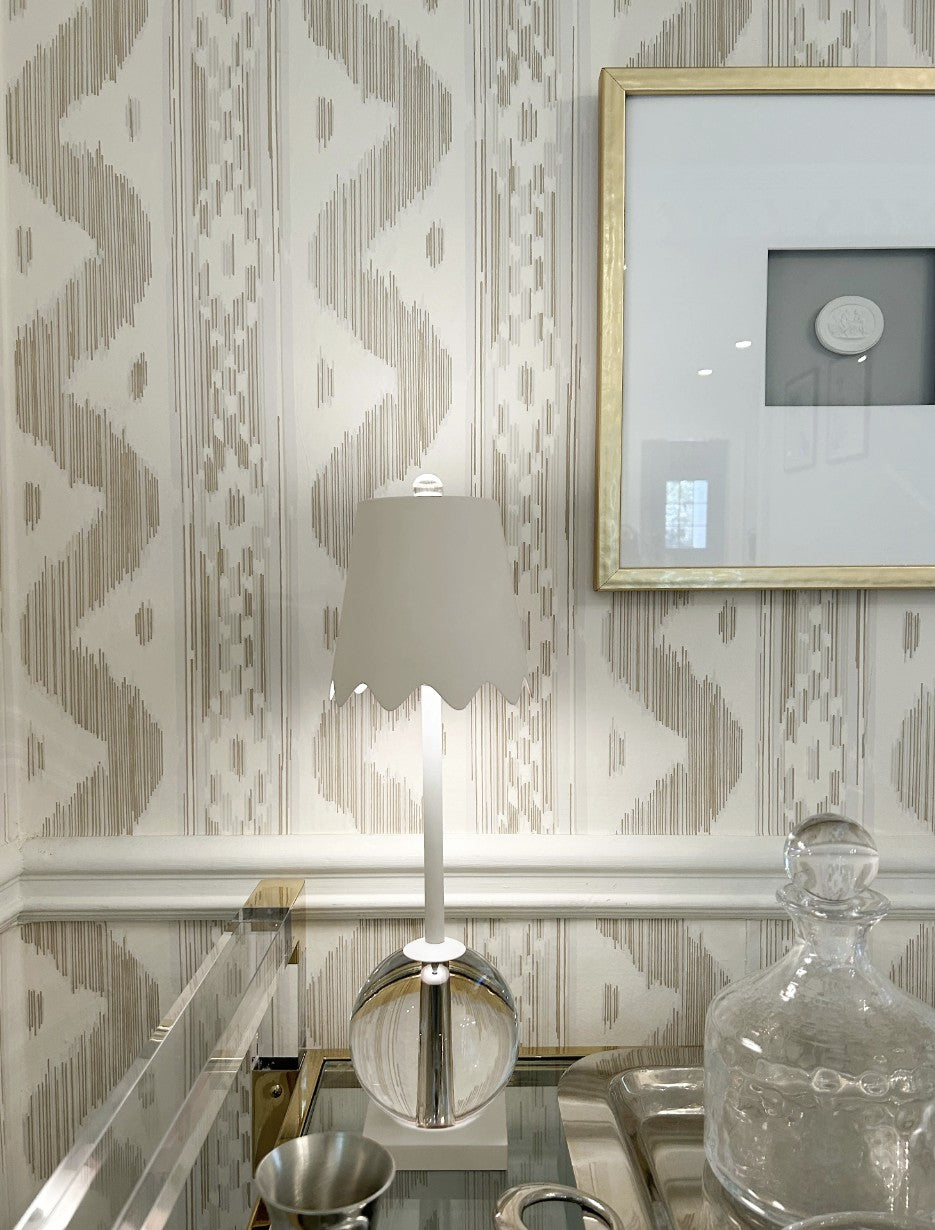 Decorative wall with geometric pattern, lamp, and framed picture.