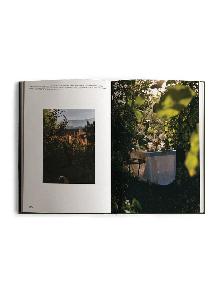 Open book showing a photograph of a garden scene with trees and a table.