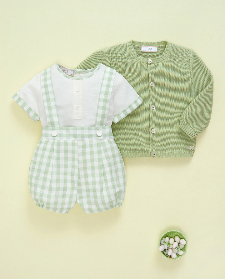 Green checkered romper and green cardigan on a light yellow background