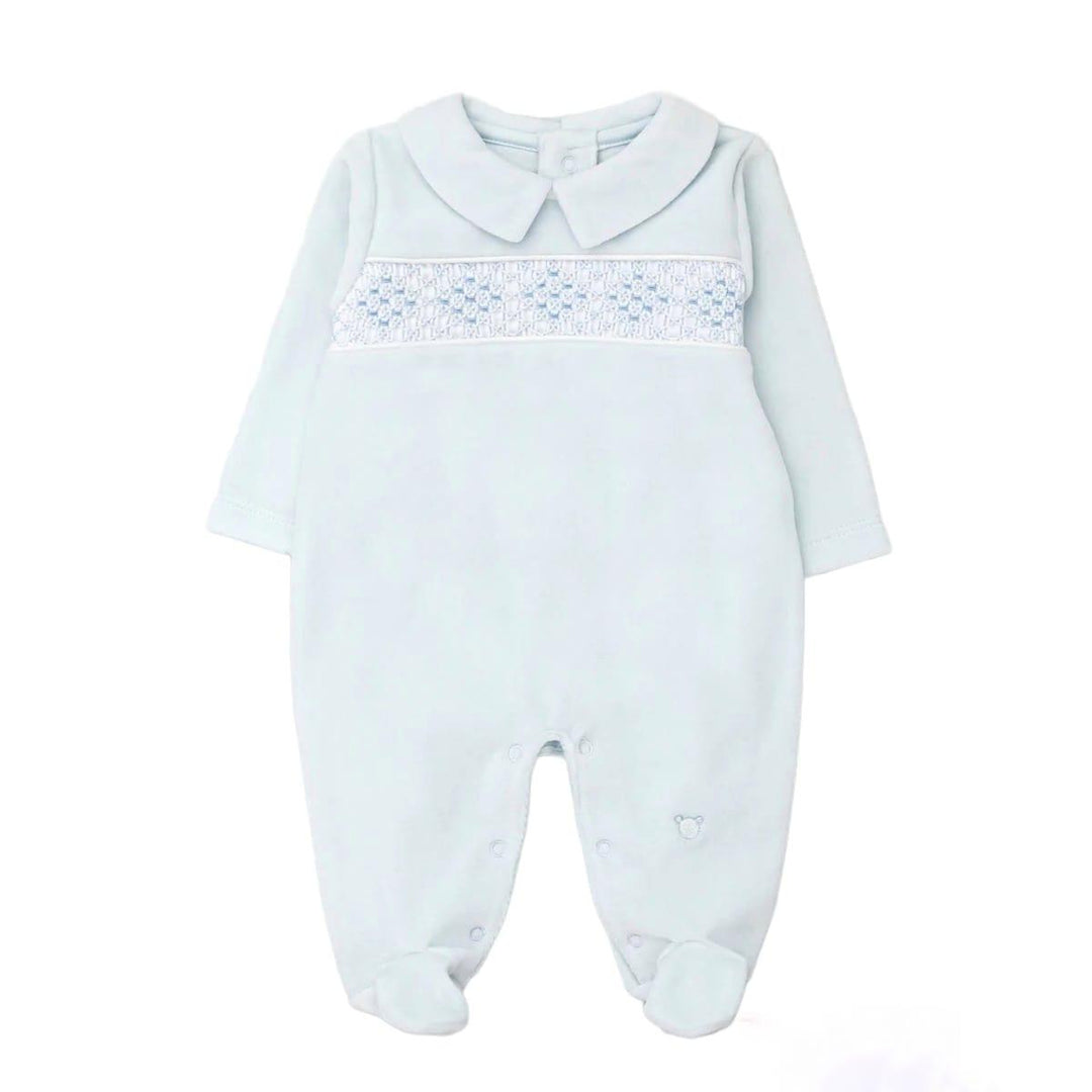 A baby long-sleeve footed romper in pale icy blue, featuring a Peter Pan collar and a smocked chest panel with blue hearts and white dots.