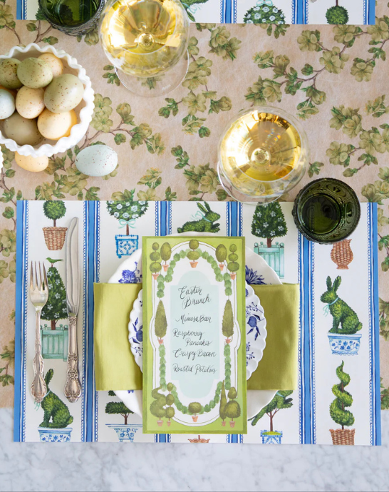 Easter-themed table setting with decorative placemats, glasses, and a menu card.