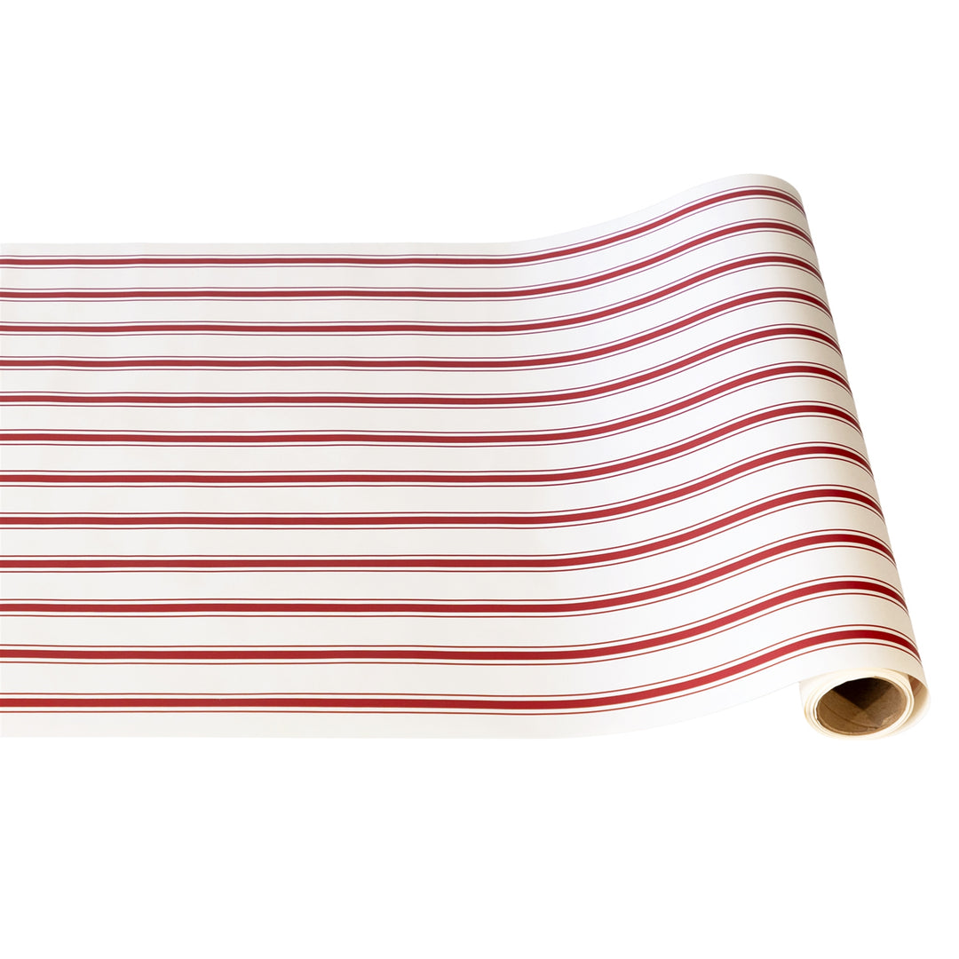 Roll of red and white striped fabric on a white background