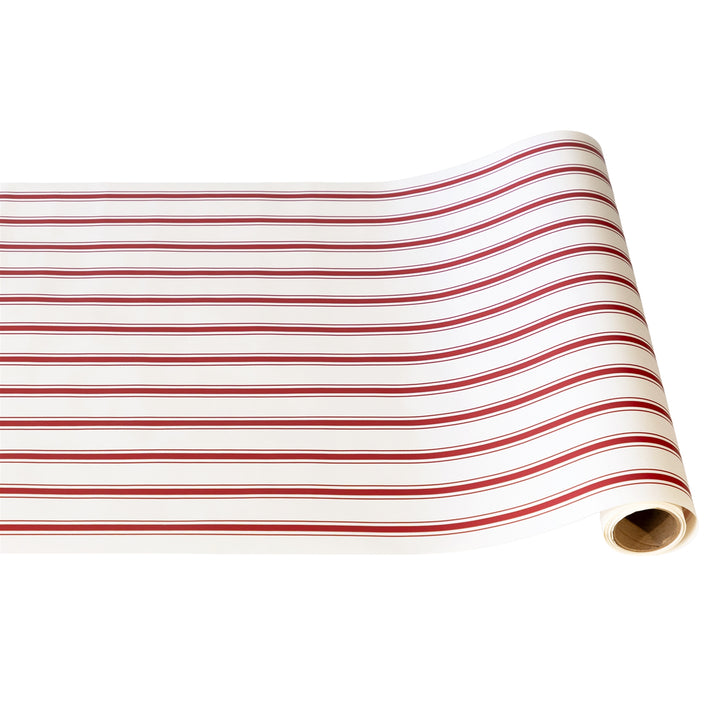Roll of red and white striped fabric on a white background