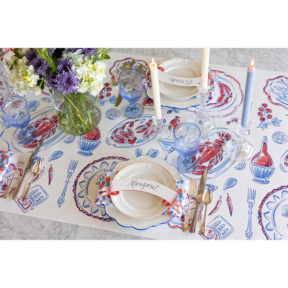 Decorative table setting with floral arrangement, candles, and patterned placemats.