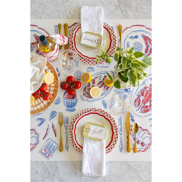 Decorative table setting with patterned placemats, plates, and cutlery on a marble surface.