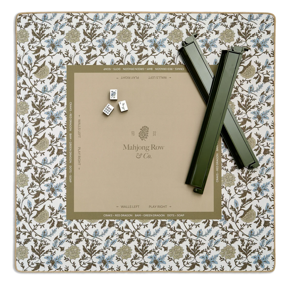 Mahjong game set with tiles and a scoring board on a floral-patterned mat