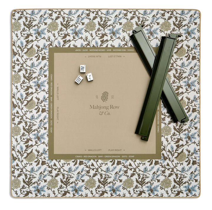 Mahjong game set with tiles and a scoring board on a floral-patterned mat