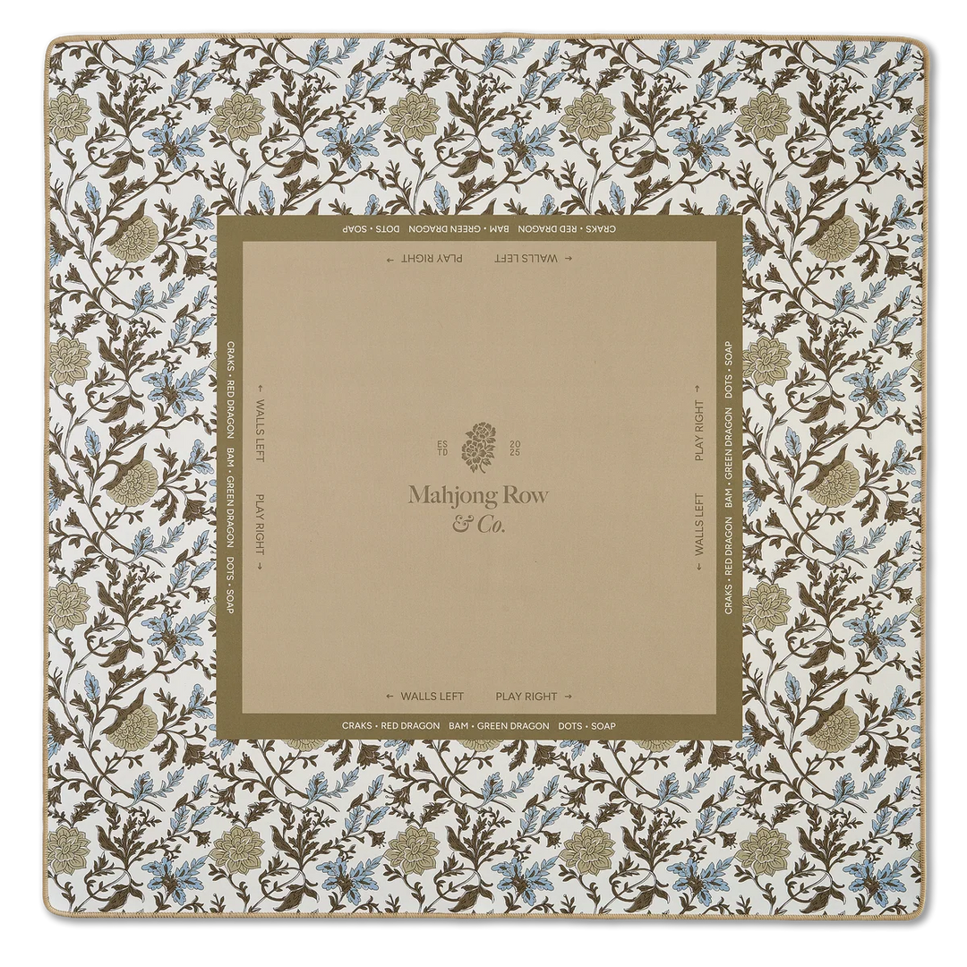 A square Mahjong Row & Co. playing card deck box or packaging insert featuring a cream background with a brown and blue floral border pattern and a central tan panel with printed branding and directional text.