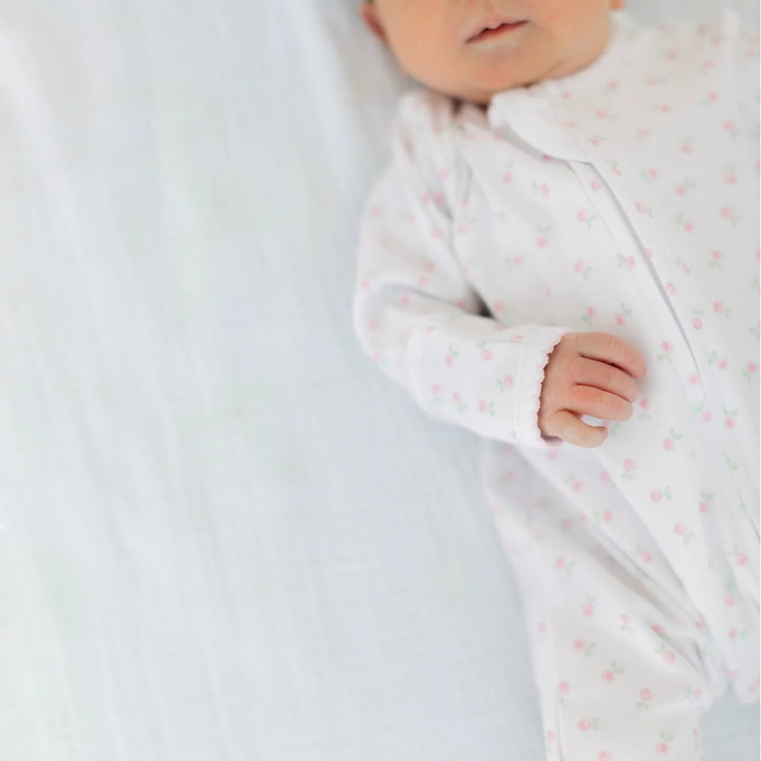 baby in whie pima cotton footie with pink flowers