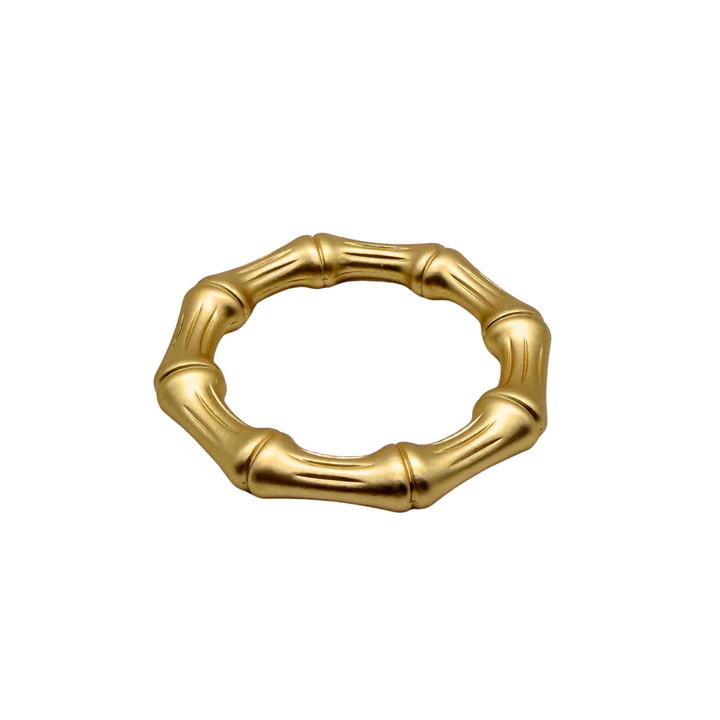 Gold napkin ring with a bamboo design on a white background