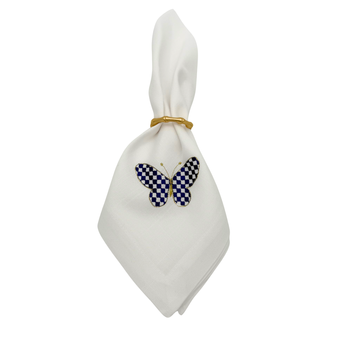 White napkin with a blue and white checkered butterfly design on a white background