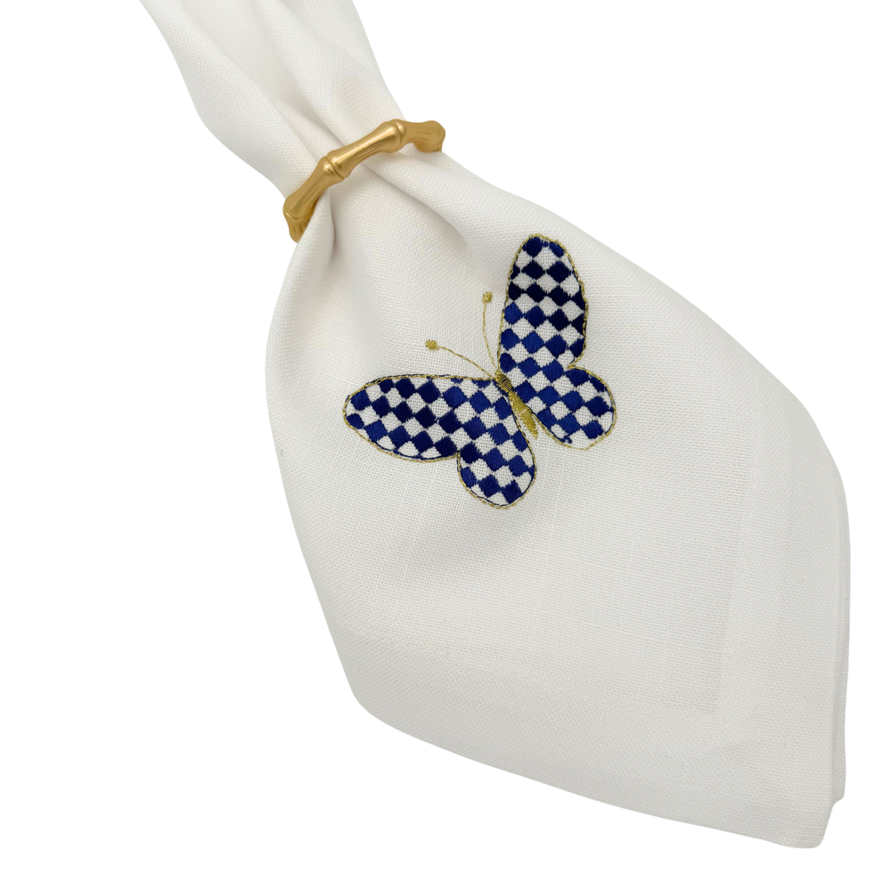 Napkin ring with a blue and white butterfly design on a white napkin.