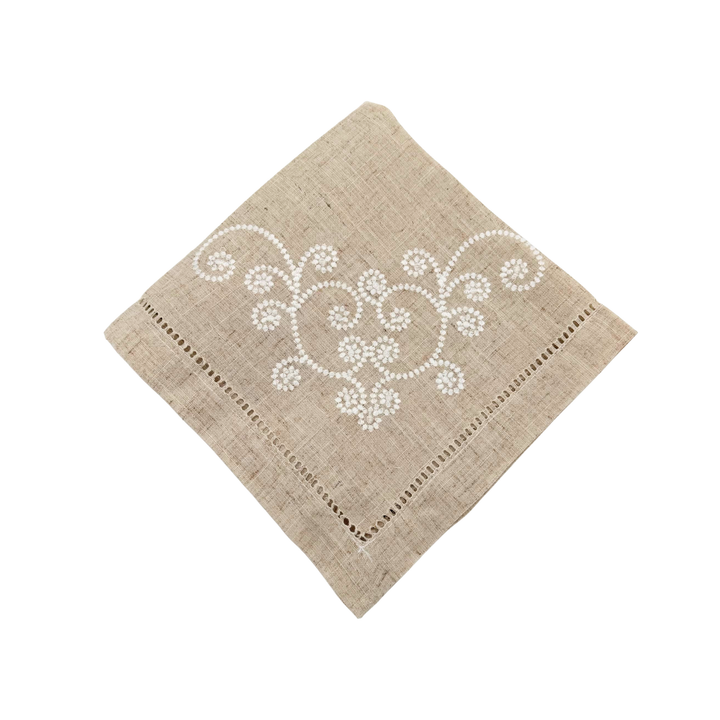 Beige napkin with white embroidery on a white background