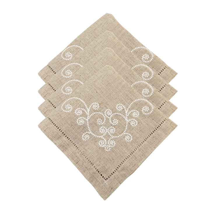 Set of four beige napkins with white floral embroidery on a white background
