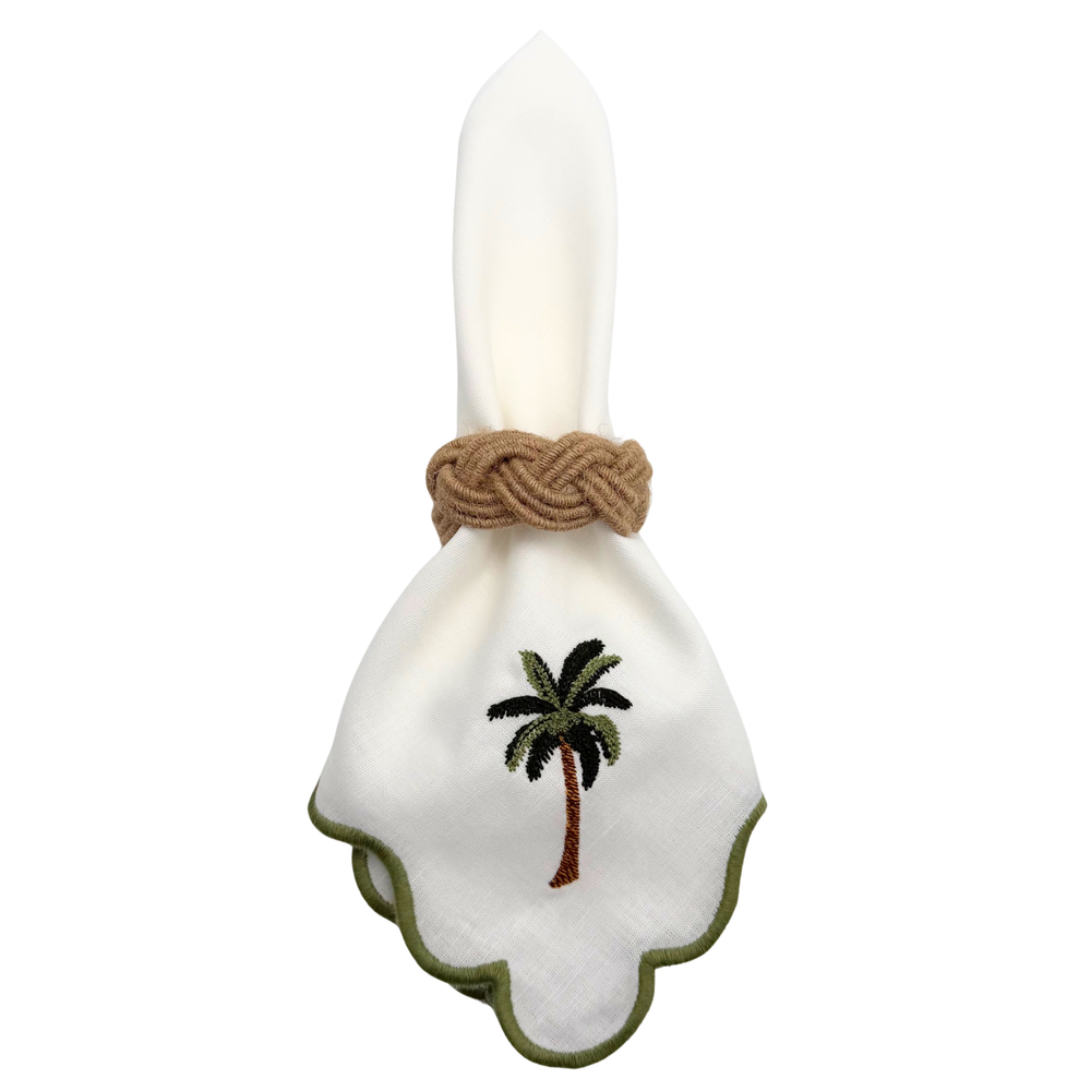 Shell-shaped napkin holder with palm tree design and rope detail on a white background