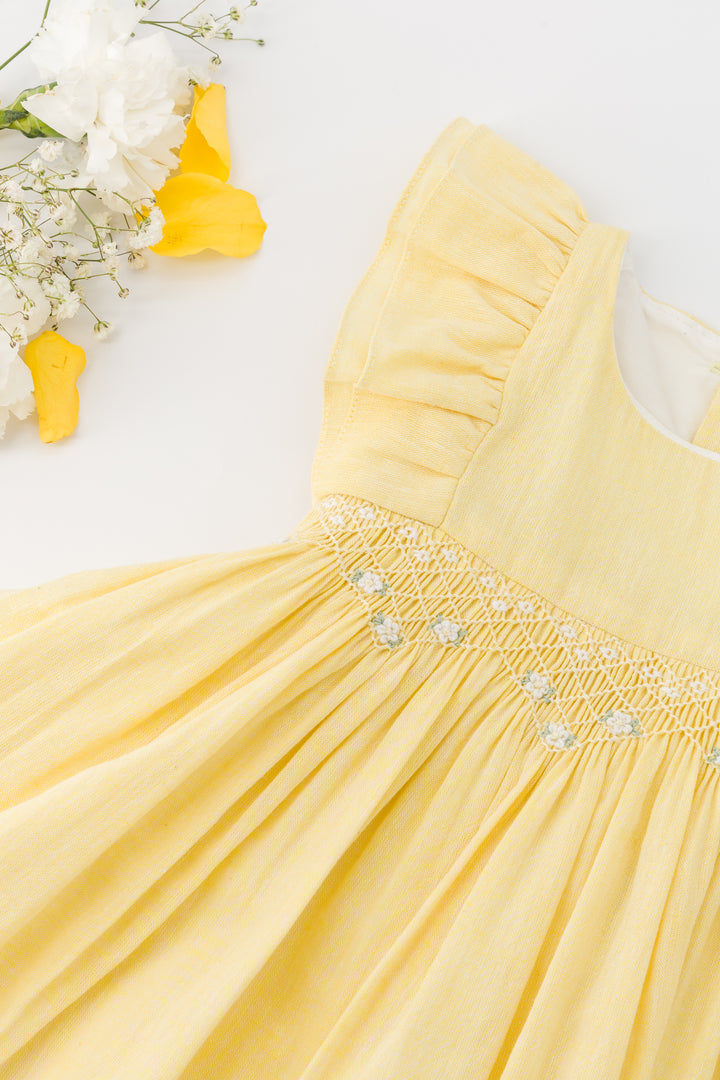 Yellow dress with floral embellishments on a light background