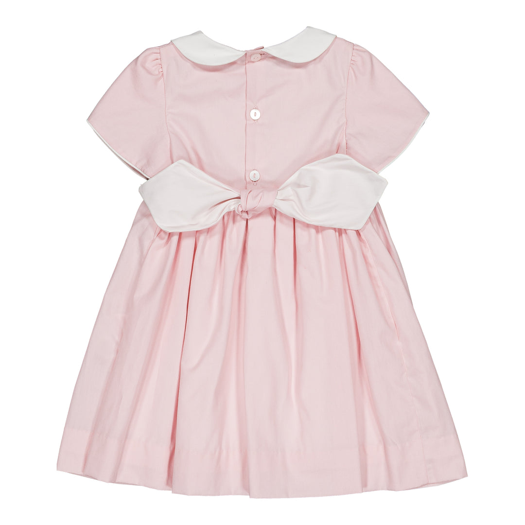 Pink dress with white collar and bow on a white background