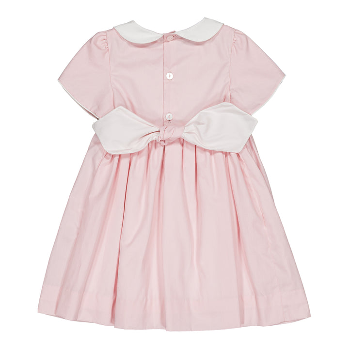 Pink dress with white collar and bow on a white background