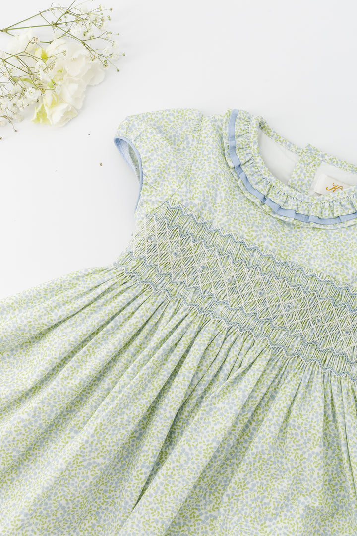 Green floral dress with smocked neckline on a light background
