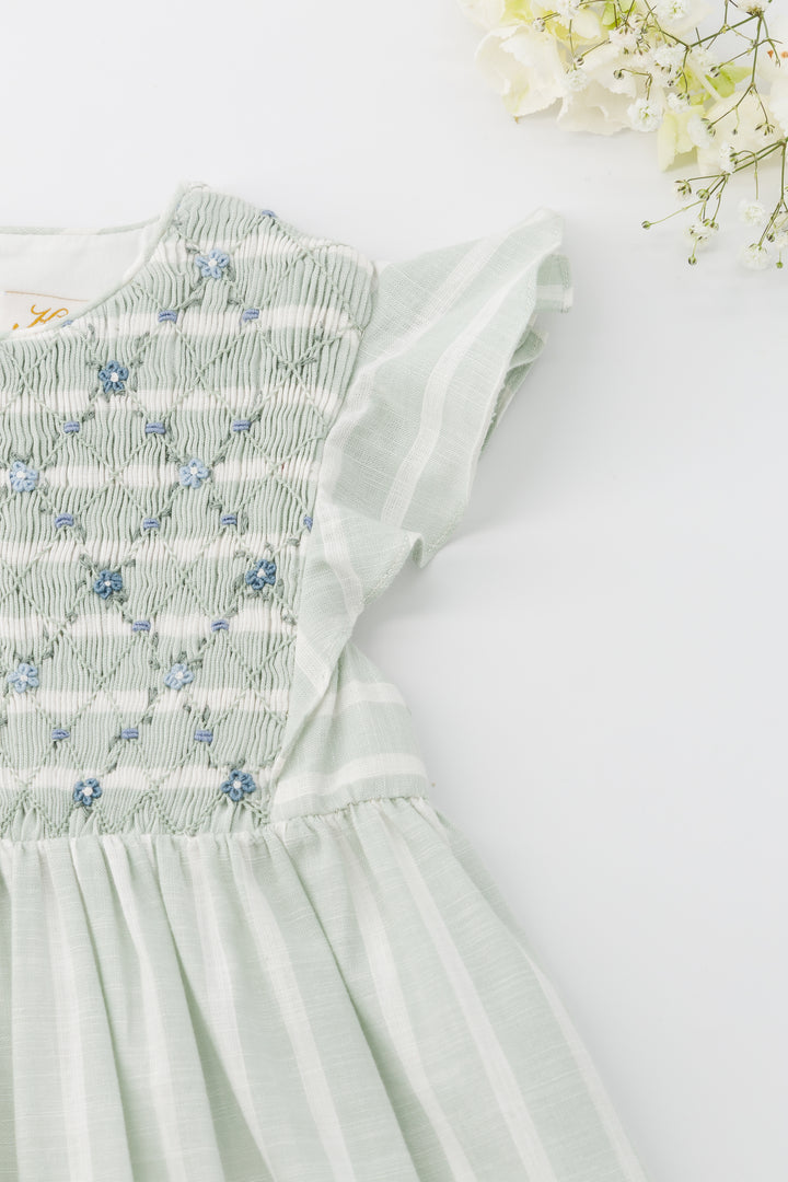 Light green dress with floral embroidery on a white background