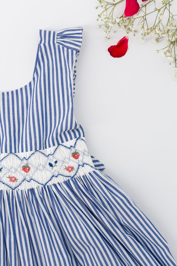 Blue and white striped dress with floral embroidery on a light gray background