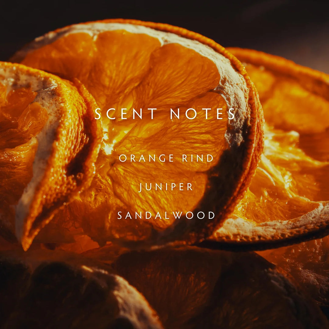 Dried orange slices with text 'SCENT NOTES: Orange Rind, Juniper, Sandalwood' on a dark background