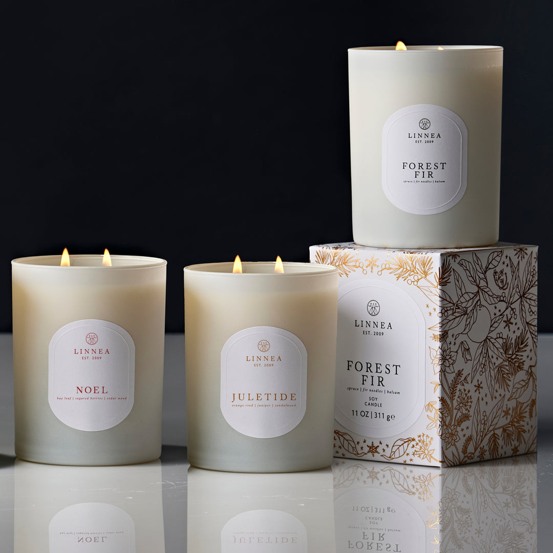 Set of Linnea candles with labels on a reflective surface