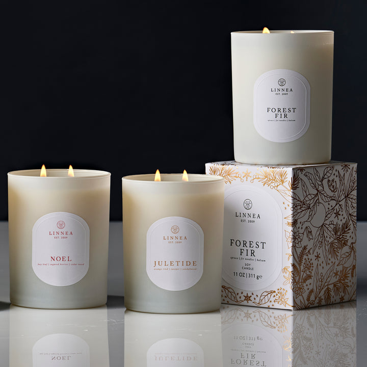 Set of Linnea candles with labels on a reflective surface