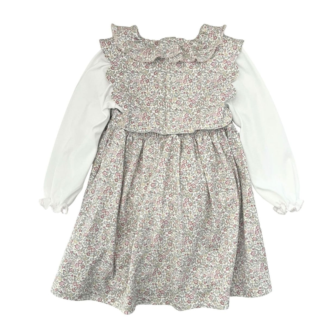 A baby girl's dress featuring a white long-sleeve blouse layered under a gray floral print skirt with a ruffled bodice and bow.