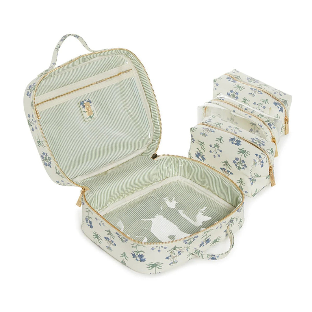 Floral-patterned travel set with a large open case and two smaller bags on a white background