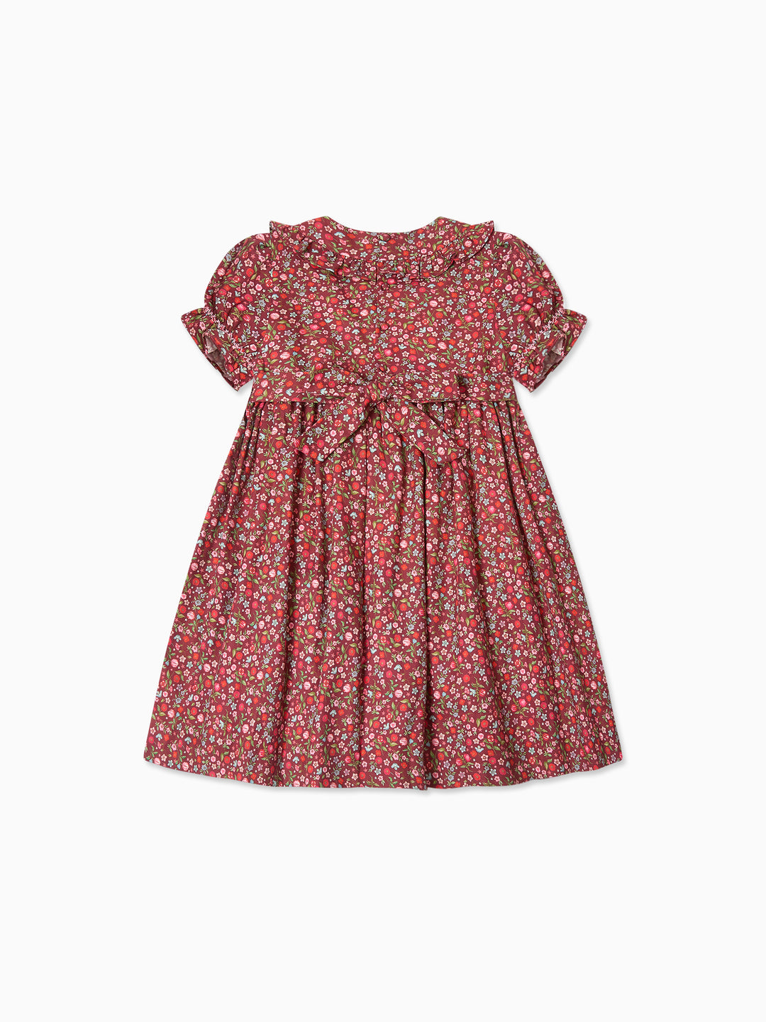 A short-sleeve children's dress with a dense red, pink, and white floral print, featuring a ruffled neckline, gathered waist, and matching bow, shown flat on a white background.