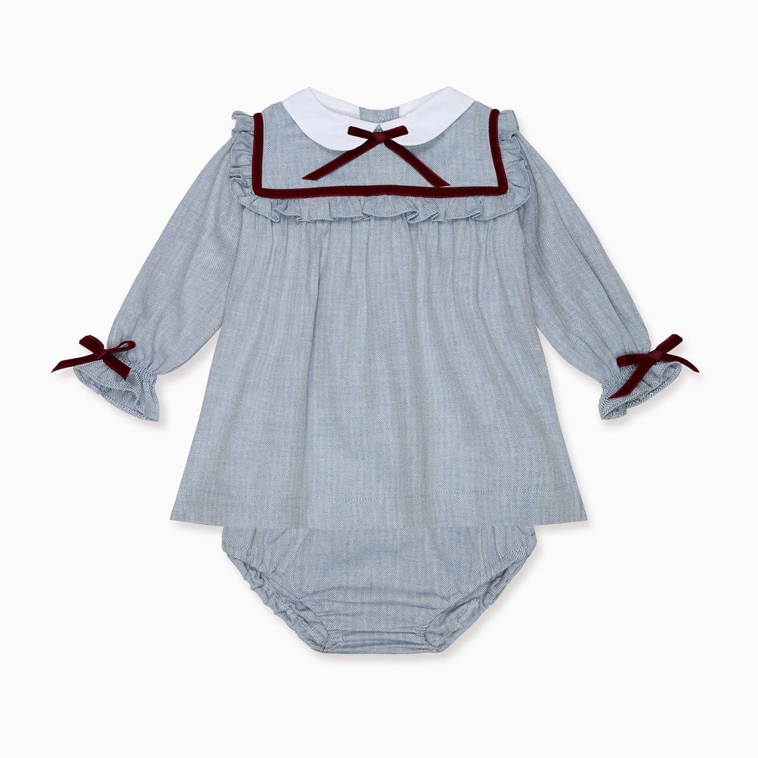 A baby long-sleeve romper in a light blue and white gingham pattern, featuring a white Peter Pan collar trimmed with dark red ribbon, a matching ruffled neckline, and dark red ribbon bows on the cuffs.
