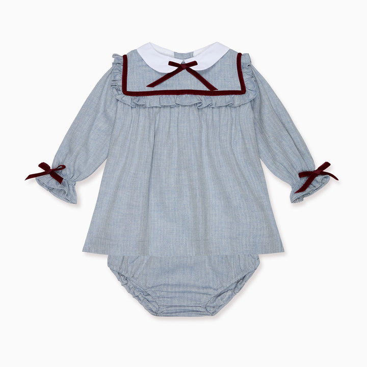 A baby long-sleeve romper in a light blue and white gingham pattern, featuring a white Peter Pan collar trimmed with dark red ribbon, a matching ruffled neckline, and dark red ribbon bows on the cuffs.