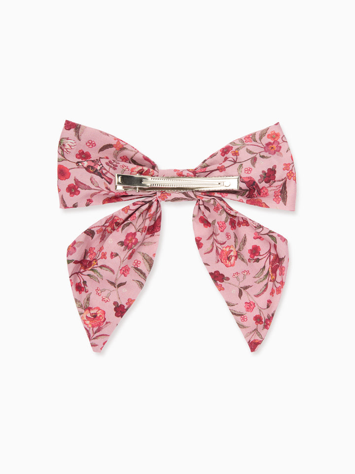A pink floral hair bow with a silver metal clip, displayed flat against a clean white background.