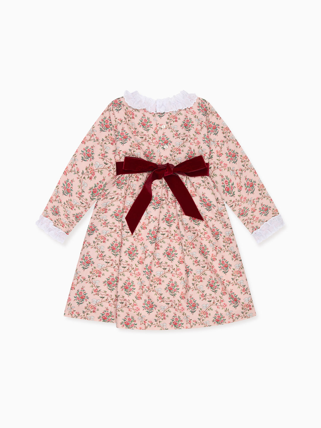 A long-sleeve baby dress with a pink and red floral print, featuring a dark red velvet bow at the waist and white ruffled trim at the collar and cuffs, shown on a plain white background.