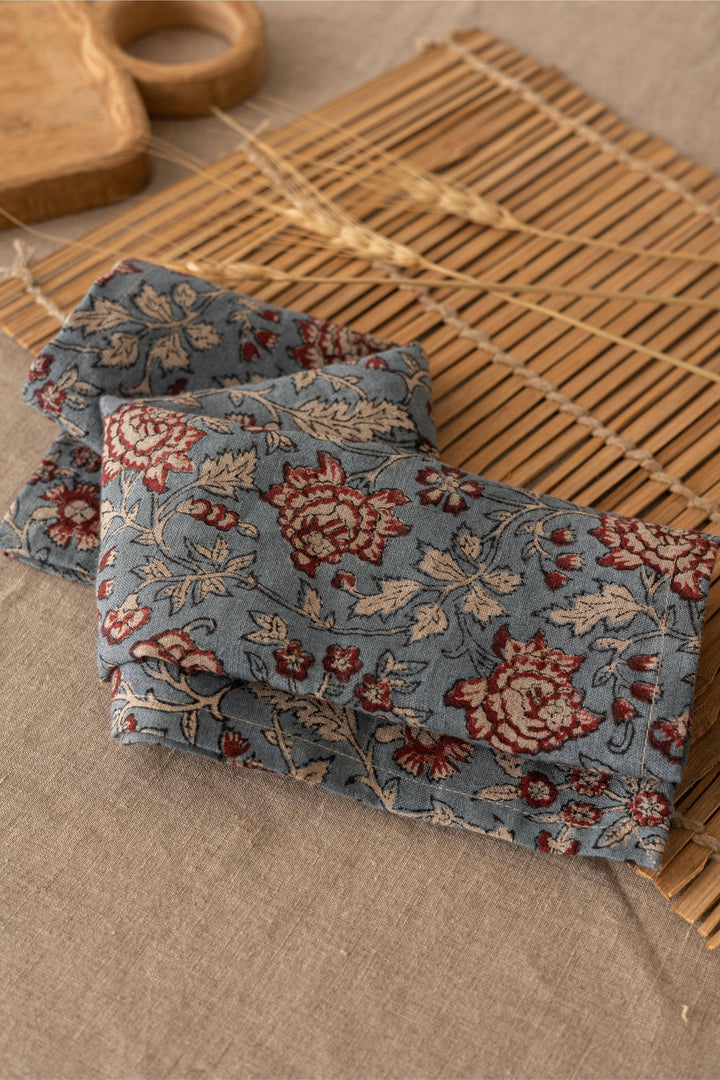 Floral-patterned fabric on a woven mat with a wooden object in the background