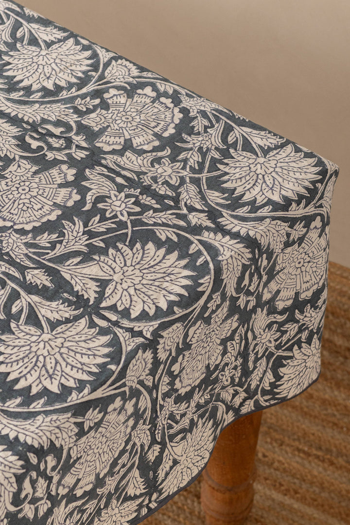 Floral patterned tablecloth on a wooden table with a neutral background