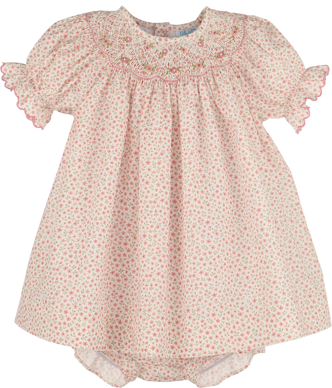 A baby girl's short-sleeve smocked dress in a light pink and green floral print, featuring ruffled sleeves and a smocked yoke with pink embroidery.