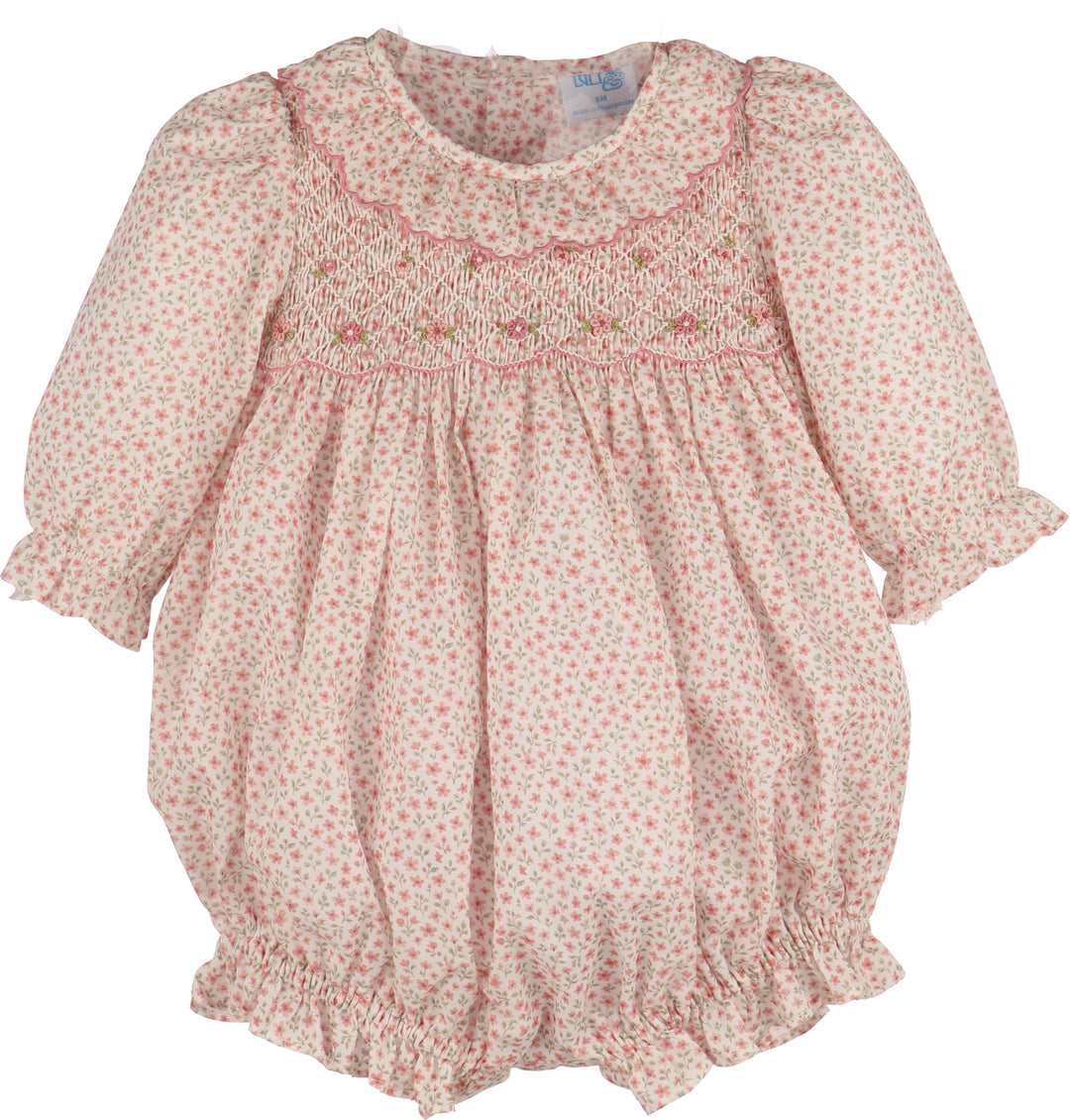 A baby girl's long-sleeve smocked bubble with pink and green floral print, featuring a smocked bodice and ruffled trim.