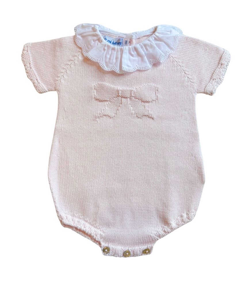 Baby romper with lace collar and bow on a white background