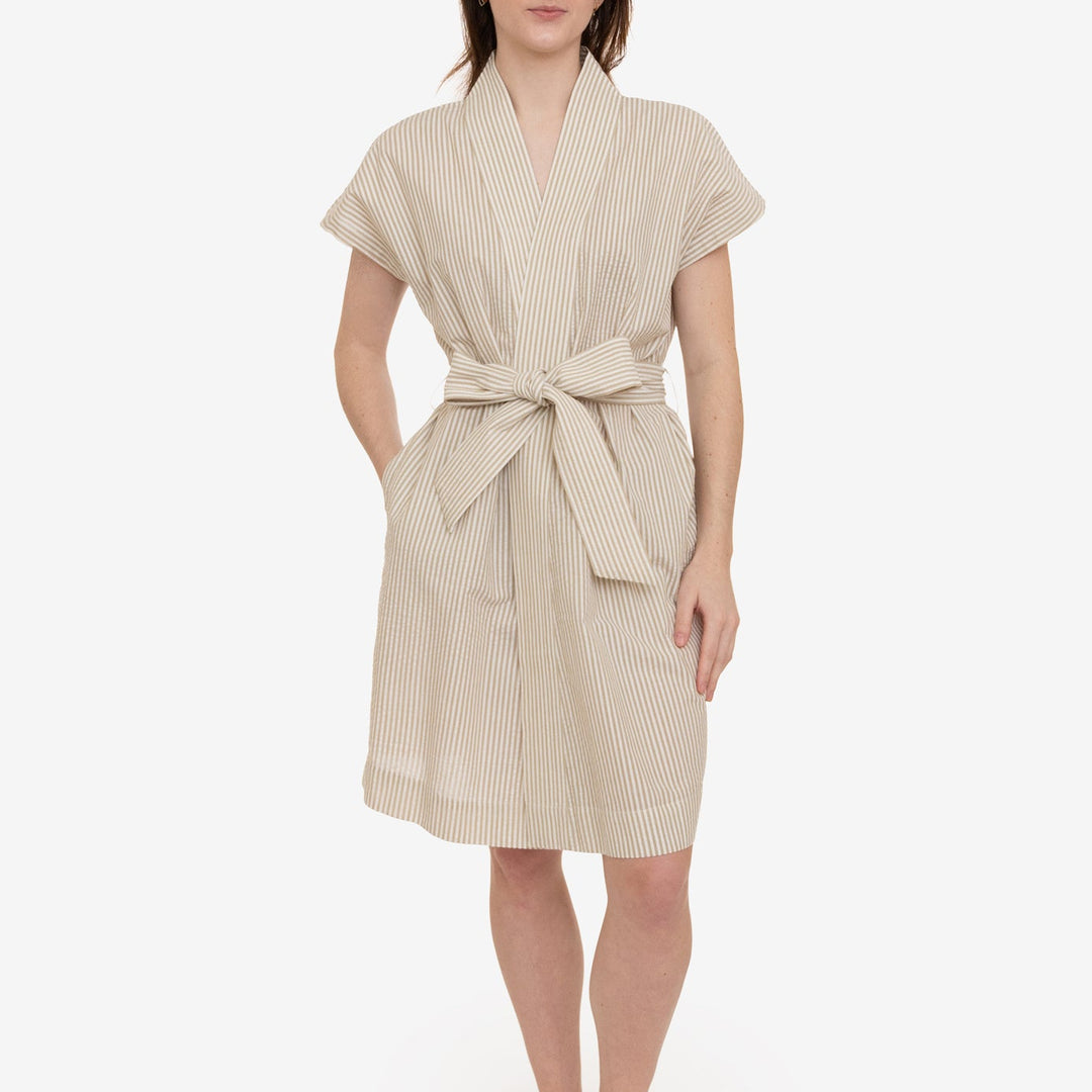 Woman wearing a beige striped robe on a white background