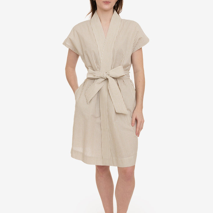 Woman wearing a beige striped robe on a white background