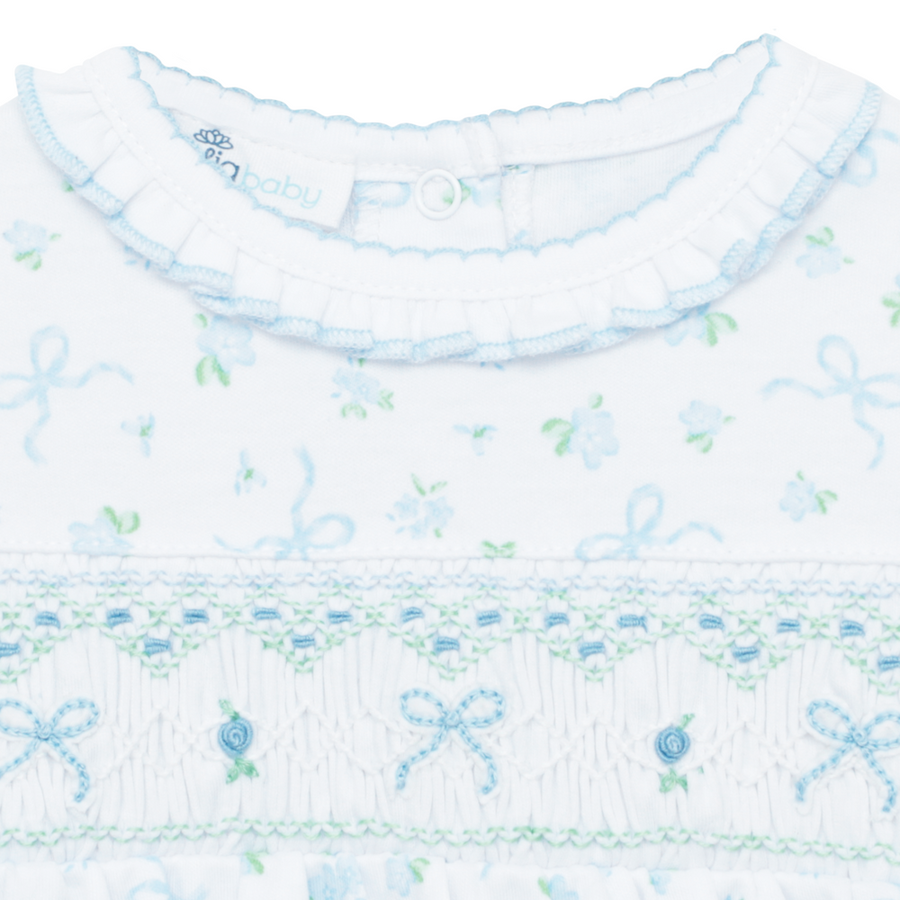 Close-up of a baby outfit with floral and bow pattern
