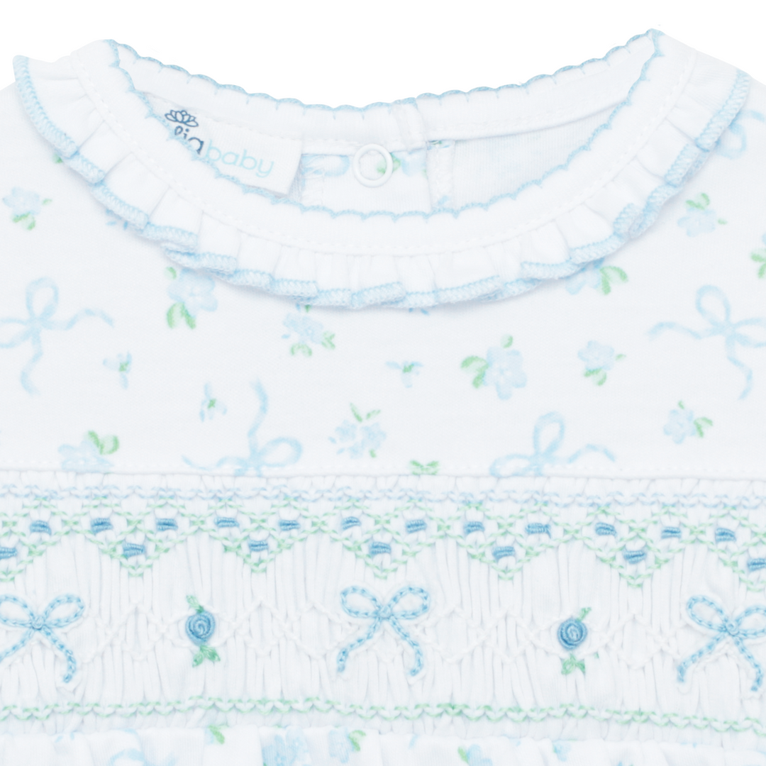 Close-up of a baby outfit with floral and bow pattern