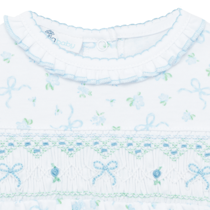 Close-up of a baby outfit with floral and bow pattern