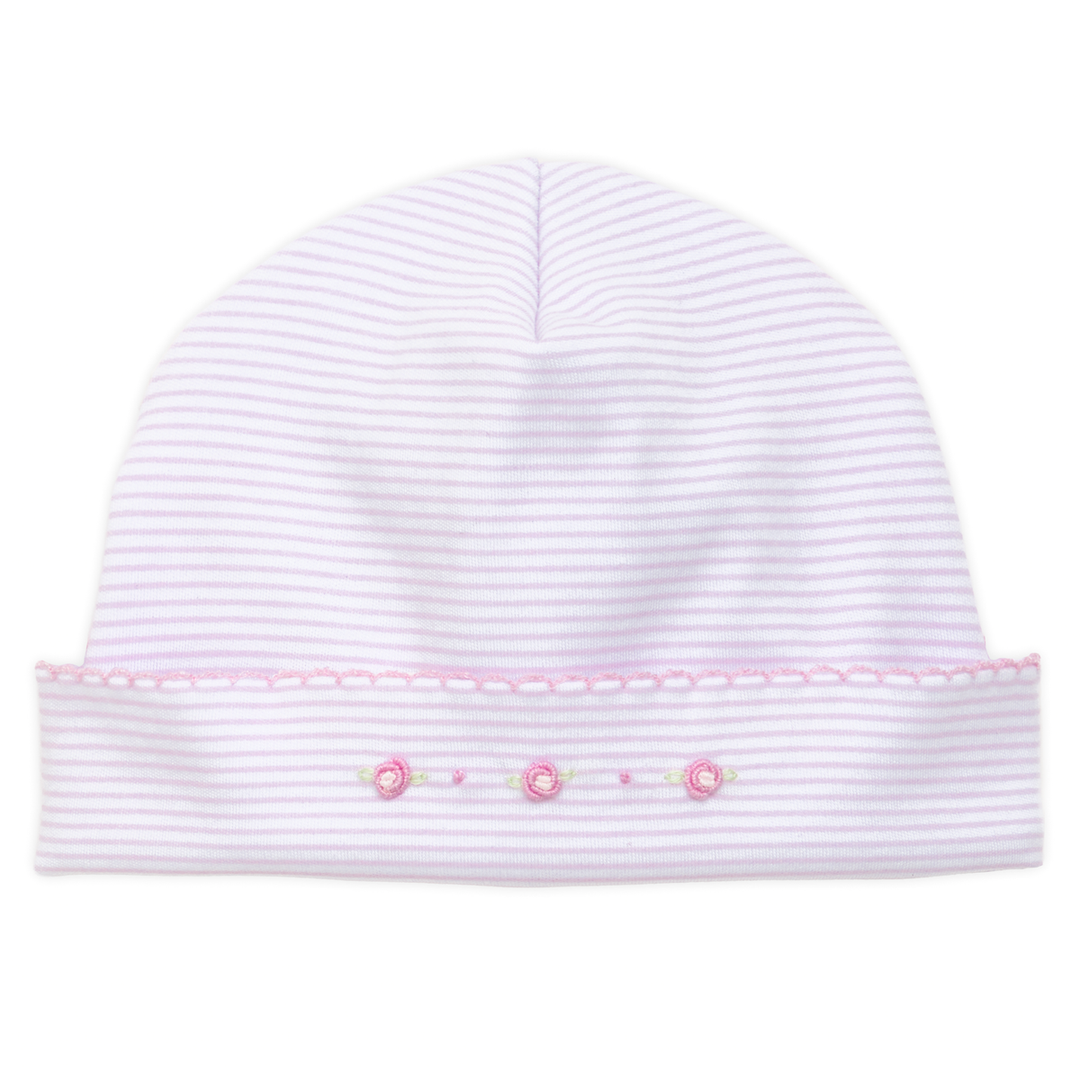 White baby hat with pink trim and decorative elements on a white background