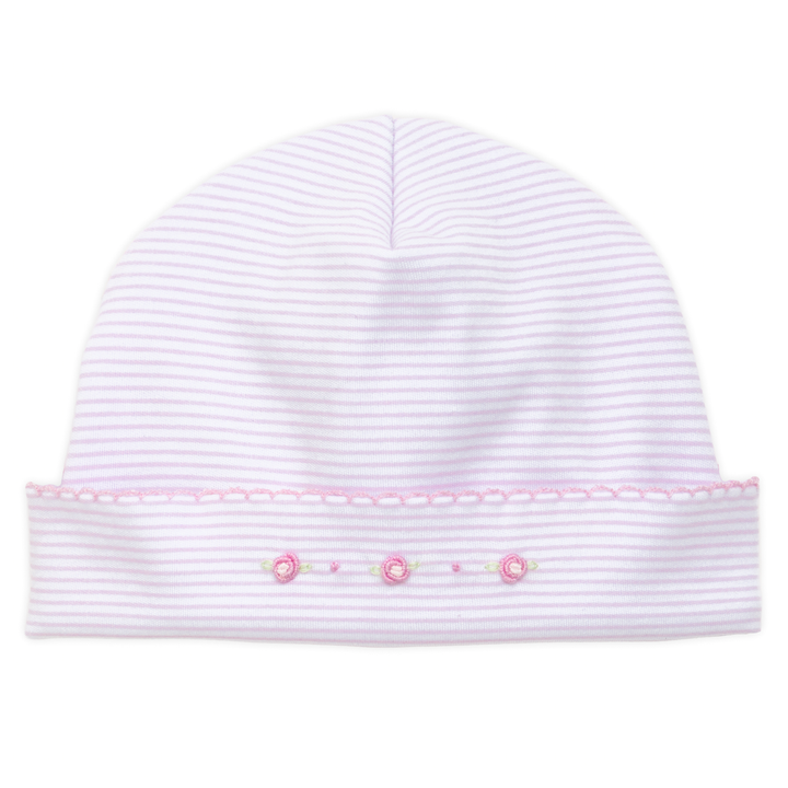 White baby hat with pink trim and decorative elements on a white background