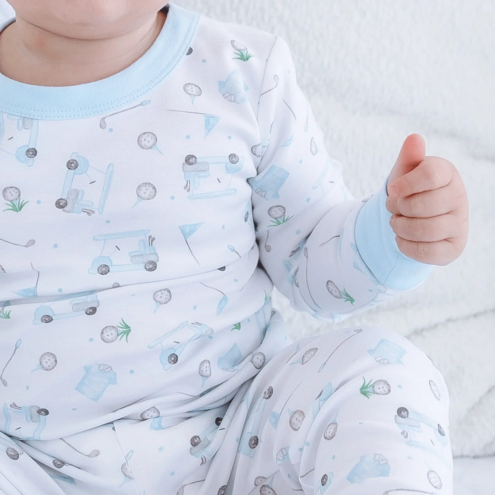 Baby wearing blue golf print pajamas