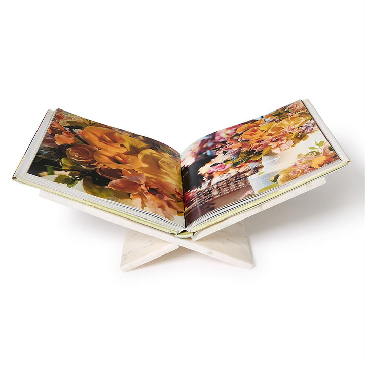 a marble book stand displaying a coffee table book